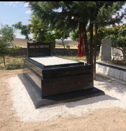 Siyah granit mezar ve kitabeli şahide, açık mezarlık