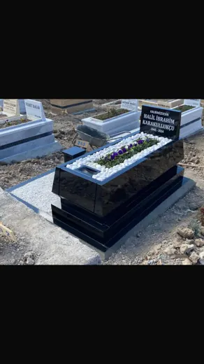 Siyah granit mezar, beyaz çakıl dolgu ve çiçek
