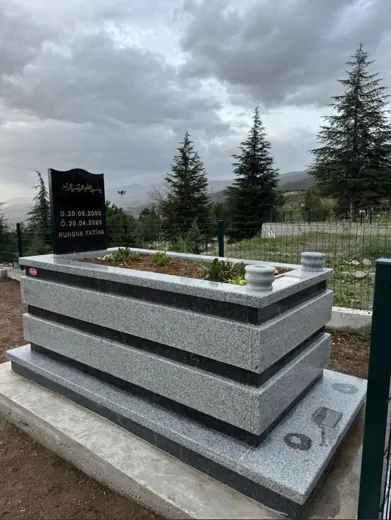 Gri granit kademeli mezar, siyah şahide, çiçekli